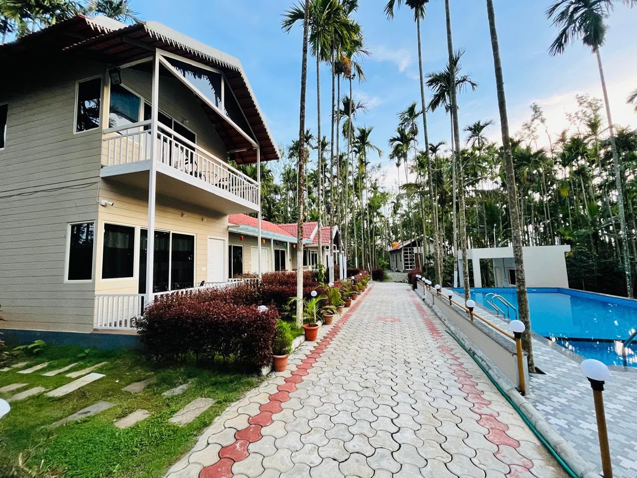 A paved pathway past the cottages towards the pool